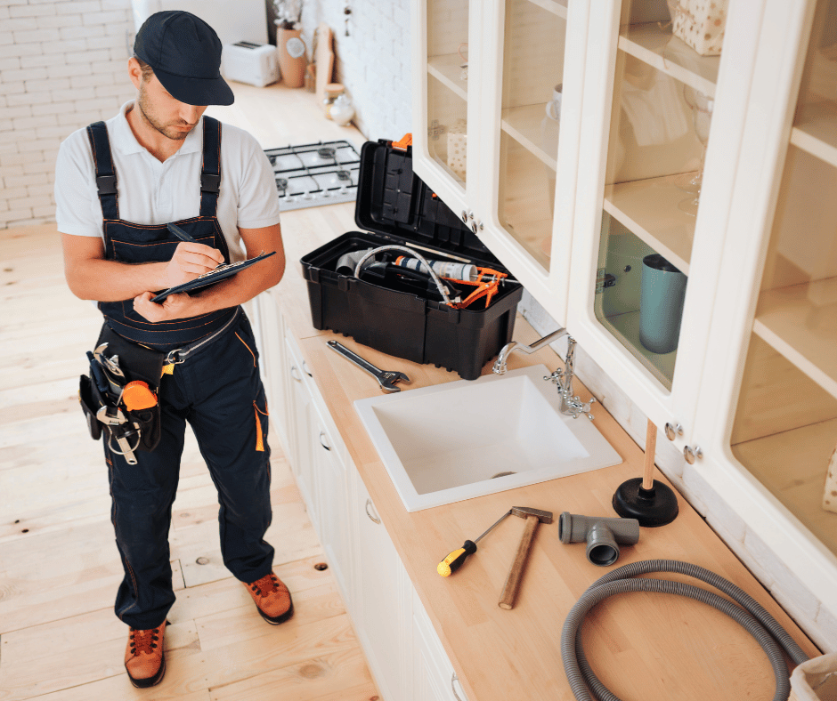 Professional plumber inspecting a kitchen sink installation and plumbing setup in a Toronto home by RenoHeal.