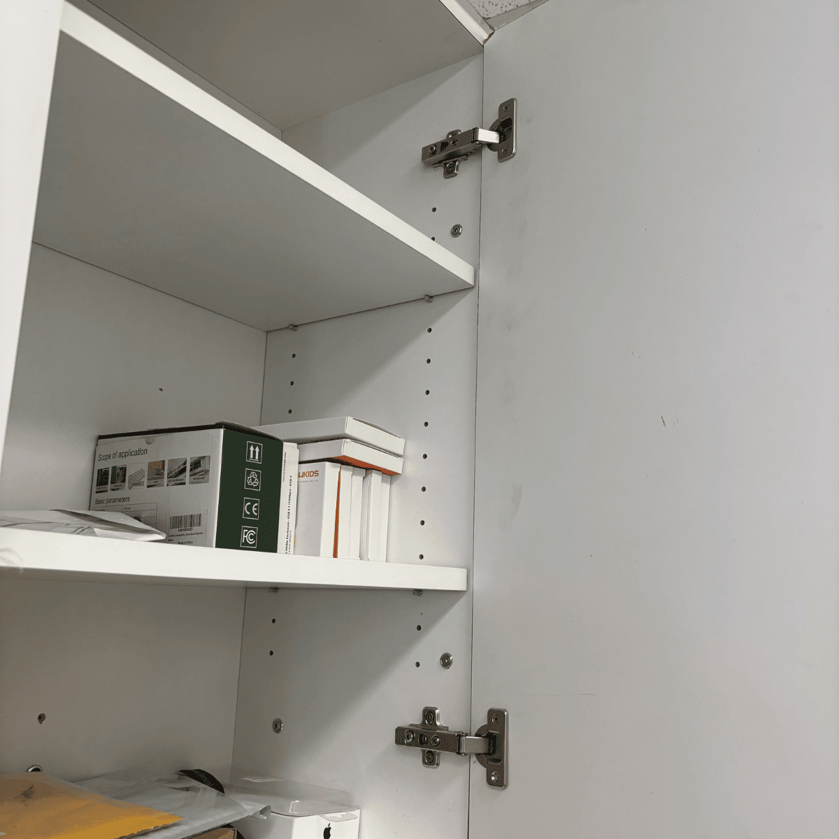 New cabinet hinge being installed on kitchen cabinet