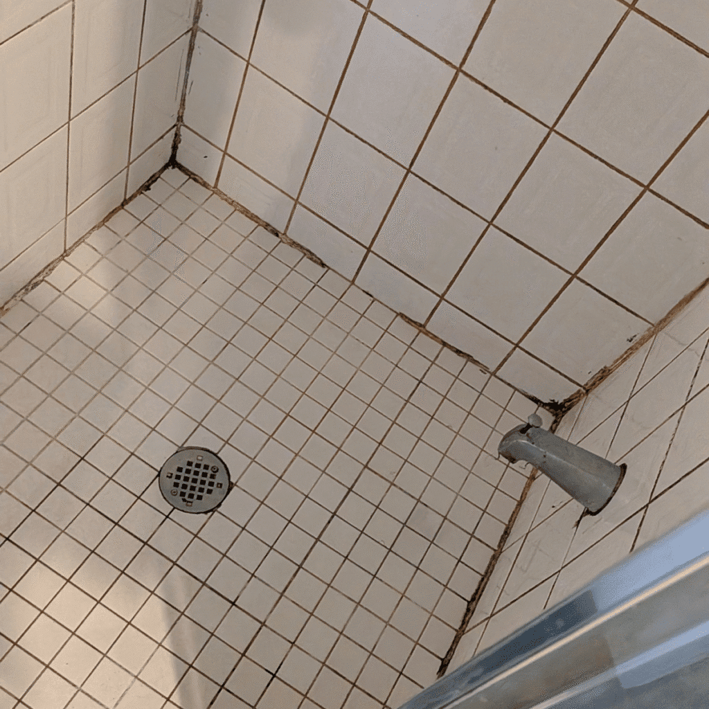 Applying silicone caulking to seal gaps in bathroom