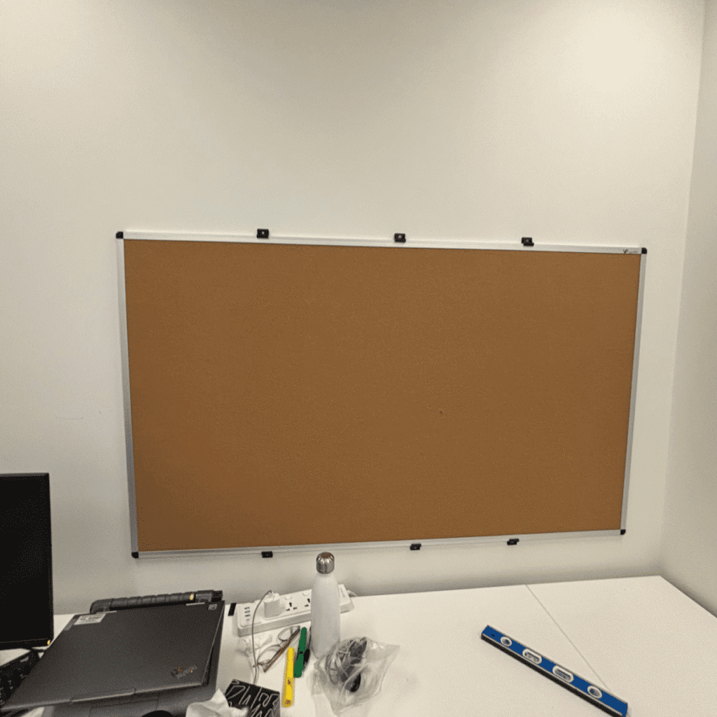 Cork board being mounted securely on wall