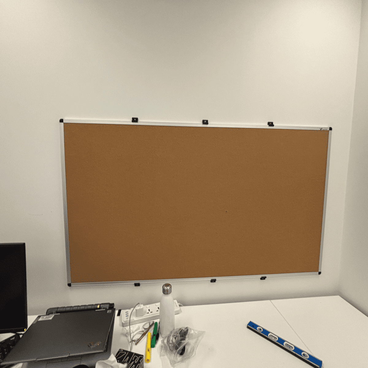 Cork board being mounted securely on wall