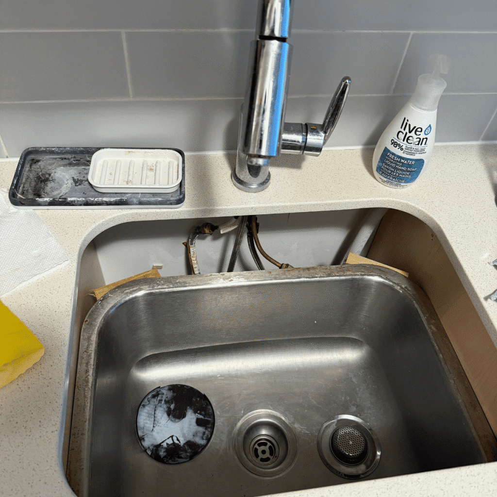 Fallen kitchen sink being repaired and reinstalled