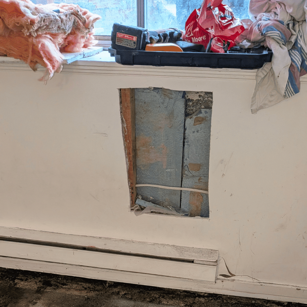 Technician smoothing drywall surface after patching