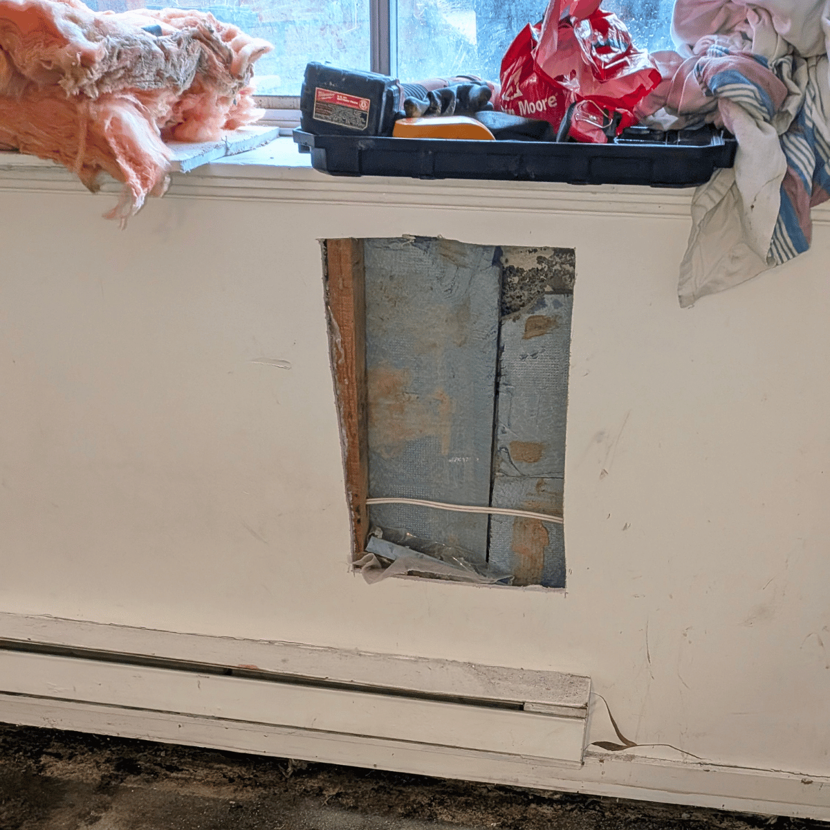 Technician smoothing drywall surface after patching