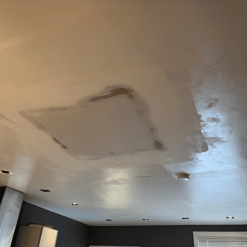 Applying fresh paint to ceiling surface with roller