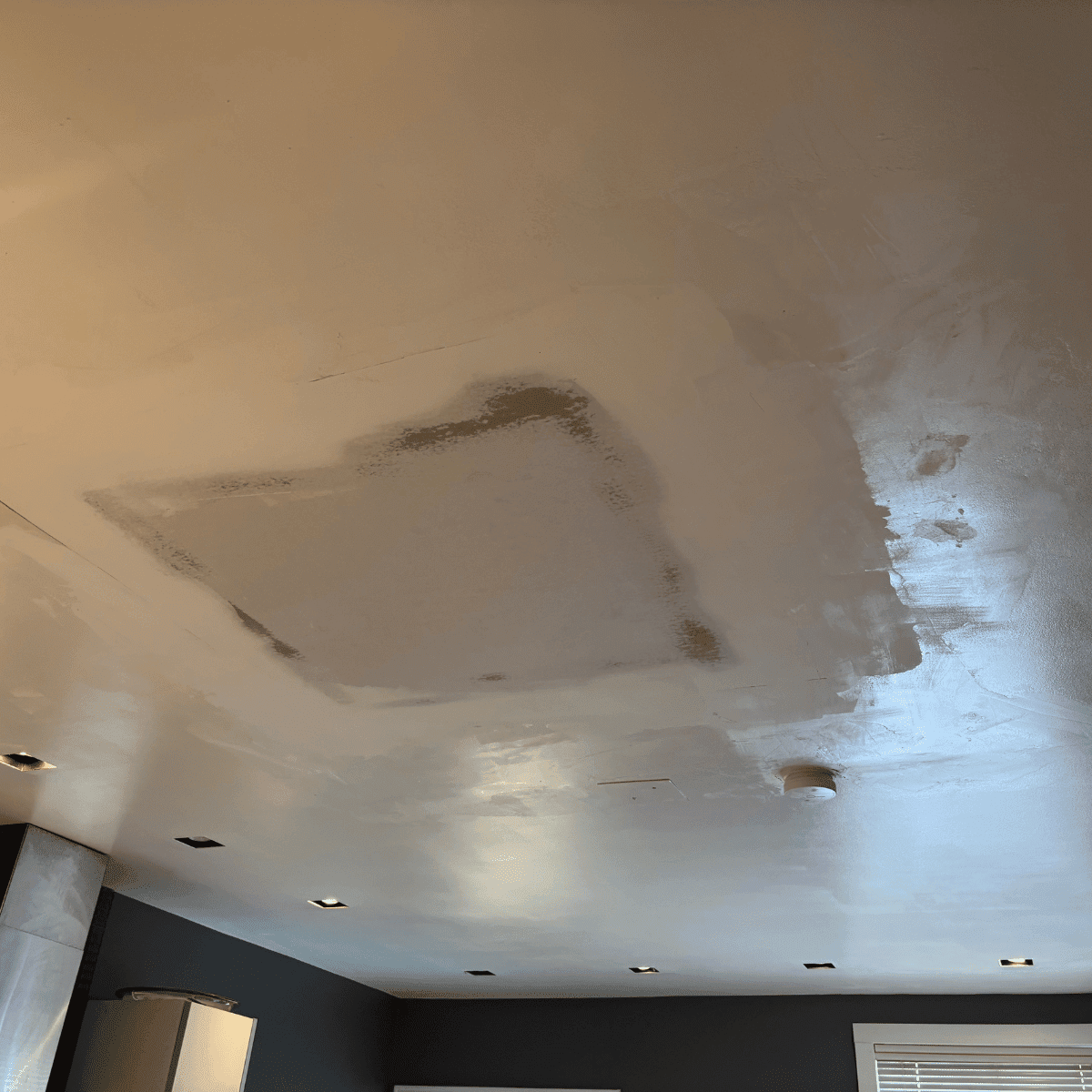 Applying fresh paint to ceiling surface with roller