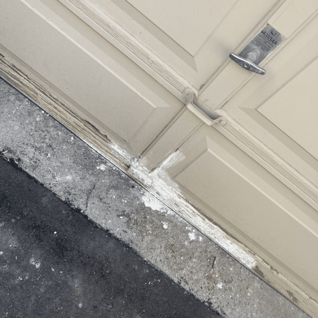 Damaged garage door being repaired and sanded