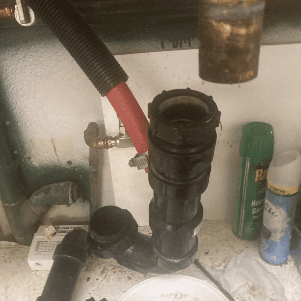 Old kitchen sink P-trap being removed due to leak