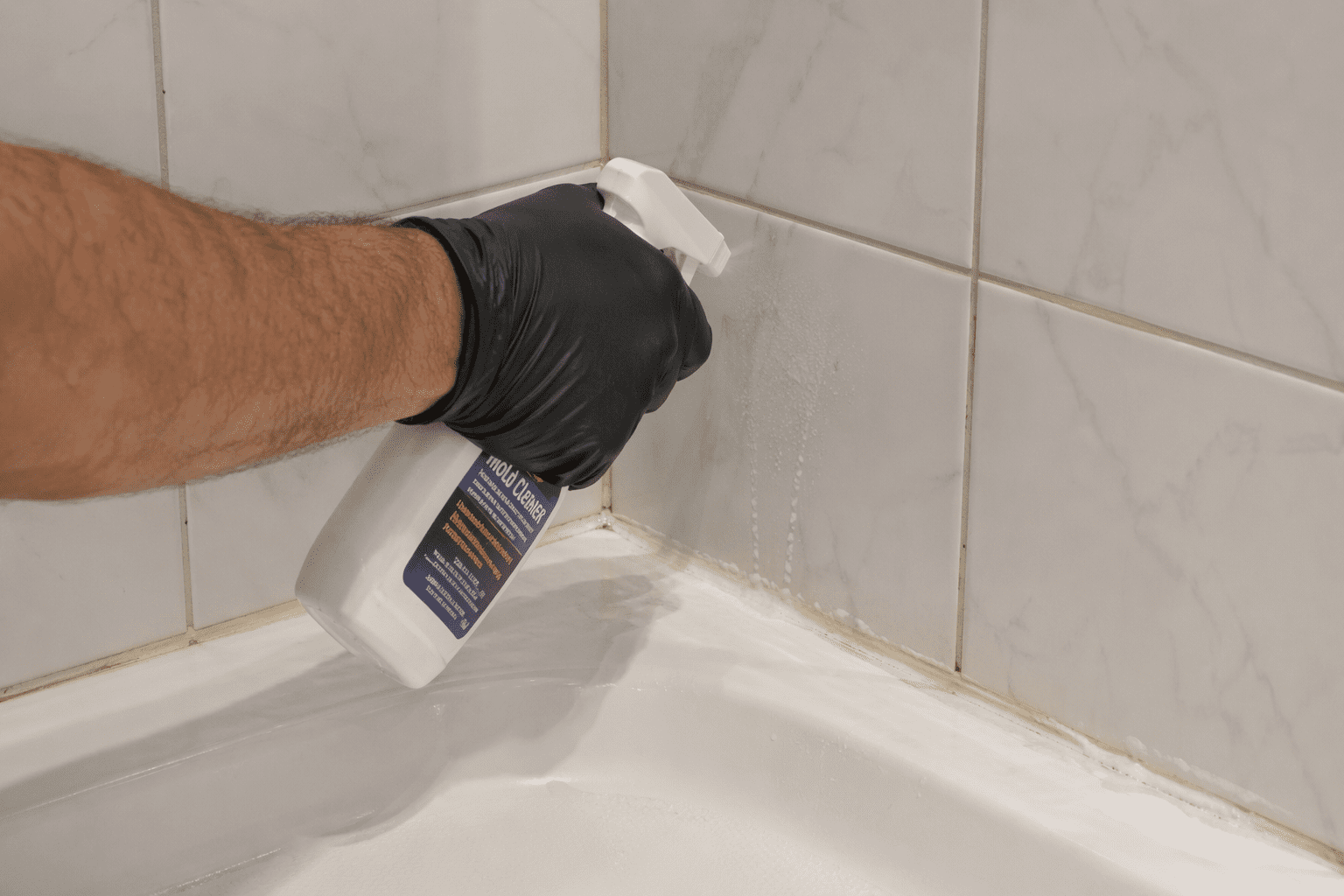 Applying mold treatment to bathroom caulking area before resealing in Toronto home