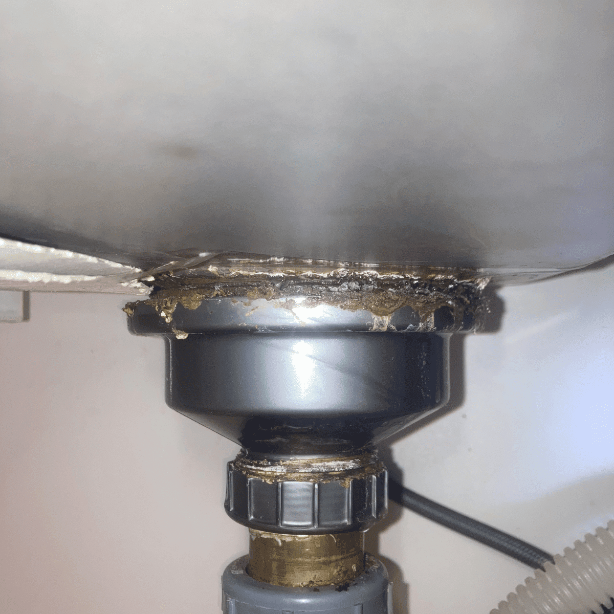 plumber installing P-trap under kitchen sink proper alignment