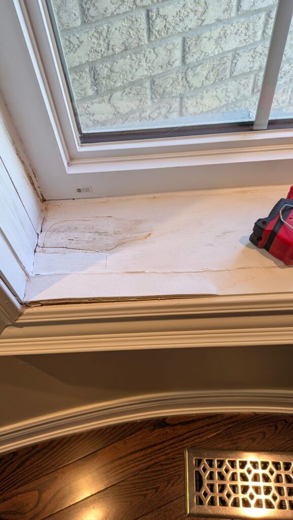 Damaged interior window sill with worn finish ready for window frame repair