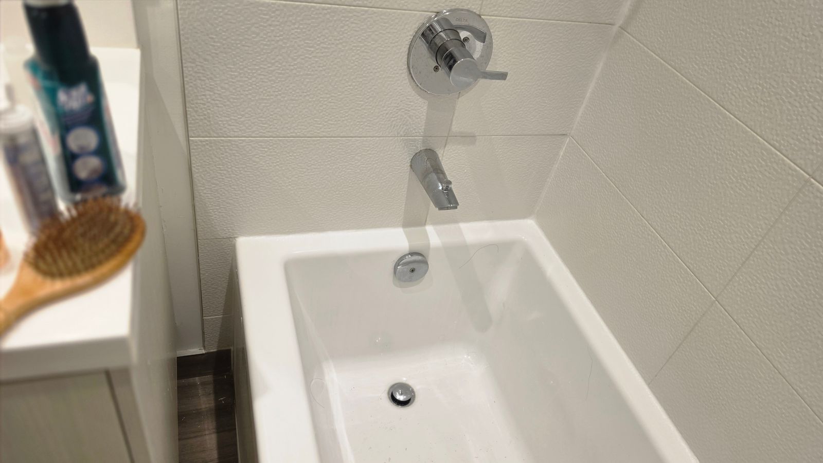 Finished bathtub recaulk with new mould-resistant silicone around the tub and faucet wall
