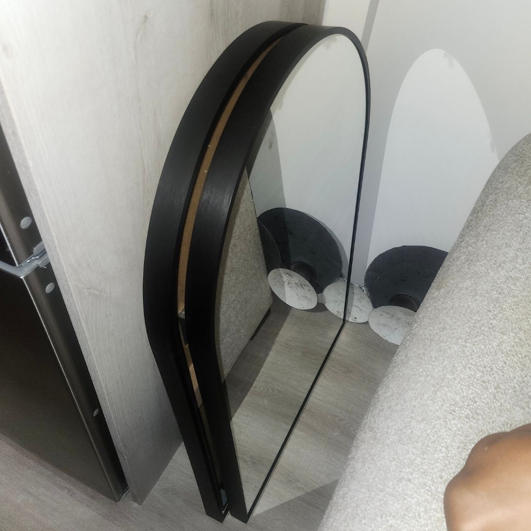 Mirror hanging service Mississauga – round black-framed mirror hung level in a hallway