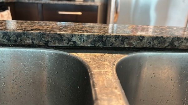 Sink reinstallation Toronto – double stainless steel sink in granite countertop