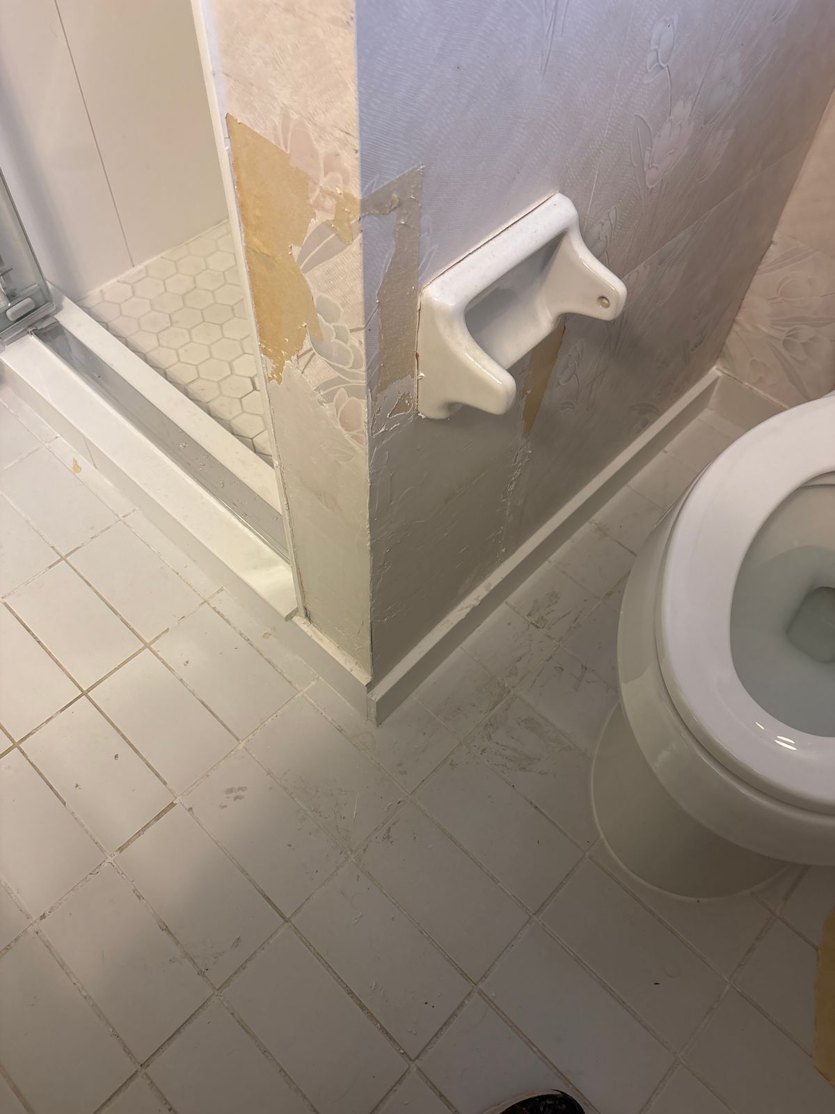 Wall repair and wallpaper repair North York – damaged bathroom wall corner beside a toilet