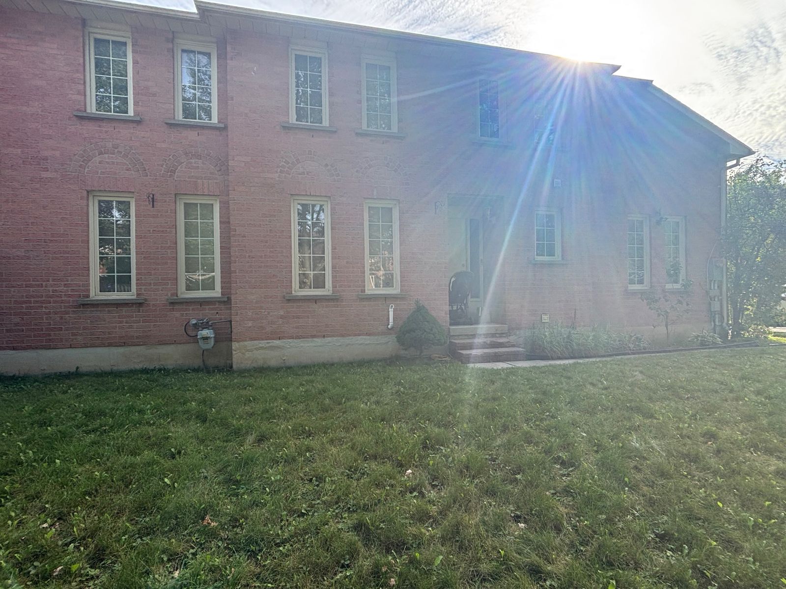 Window caulking and painting Richmond Hill – two-storey brick home with windows prepared for resealing