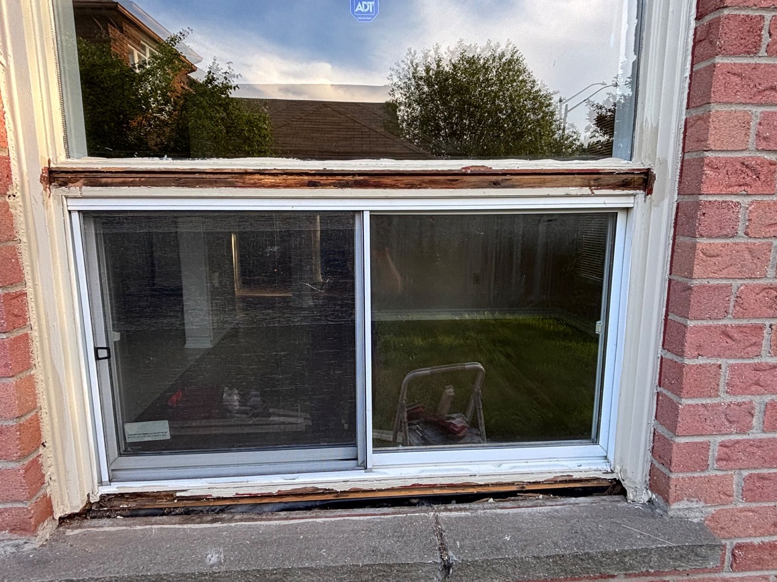 Window sill with peeling paint and failed caulk ready for sanding, caulking and repainting
