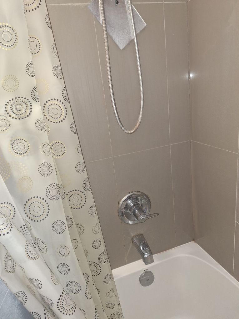 Shower caulking Toronto – tub and tile shower surround with caulk lines checked for mould and gaps